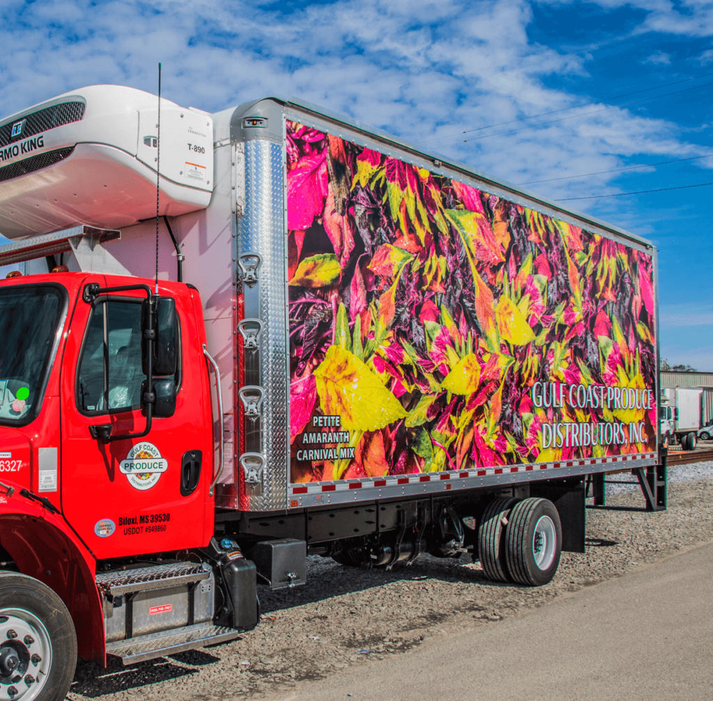 a Gulf Coast Produce Distributors Inc. delivery truck with a picture of petite amaranth on the side